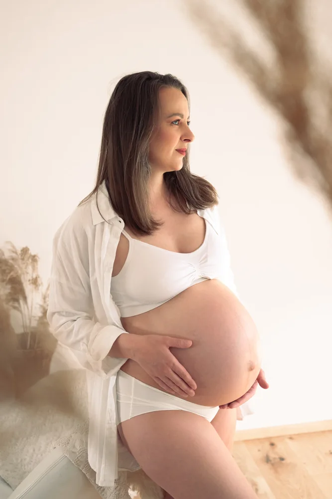 Babybauchporträt im hellen Studio.